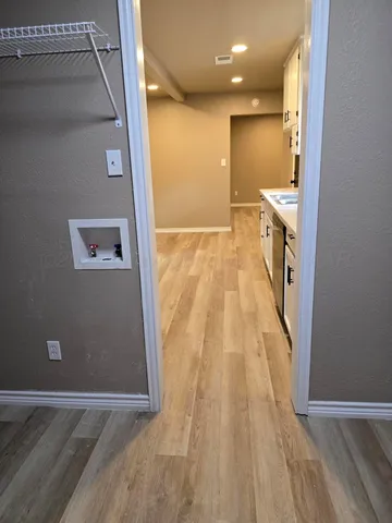 a view of a hallway with wooden floor