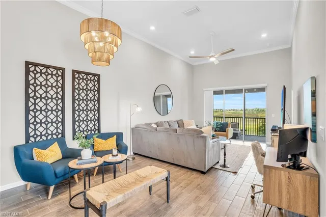 a living room with furniture chandelier and a large window