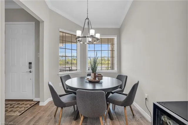 a dining room with furniture a chandelier and wooden floor