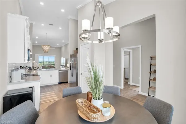 a living room with kitchen chandelier and fireplace