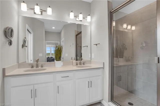 a bathroom with a double vanity sink mirror and shower