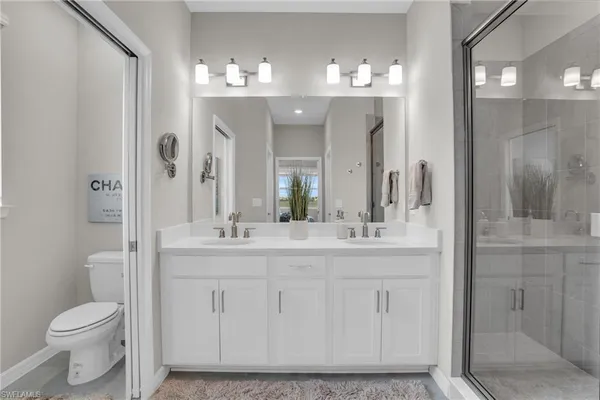 a bathroom with a granite countertop sink a toilet and shower