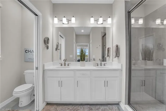 a bathroom with a granite countertop sink a toilet and shower