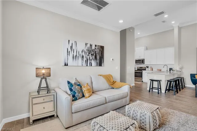a living room with furniture and a dining table with wooden floor
