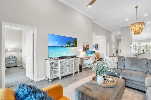 a living room with furniture kitchen view and a wooden floor