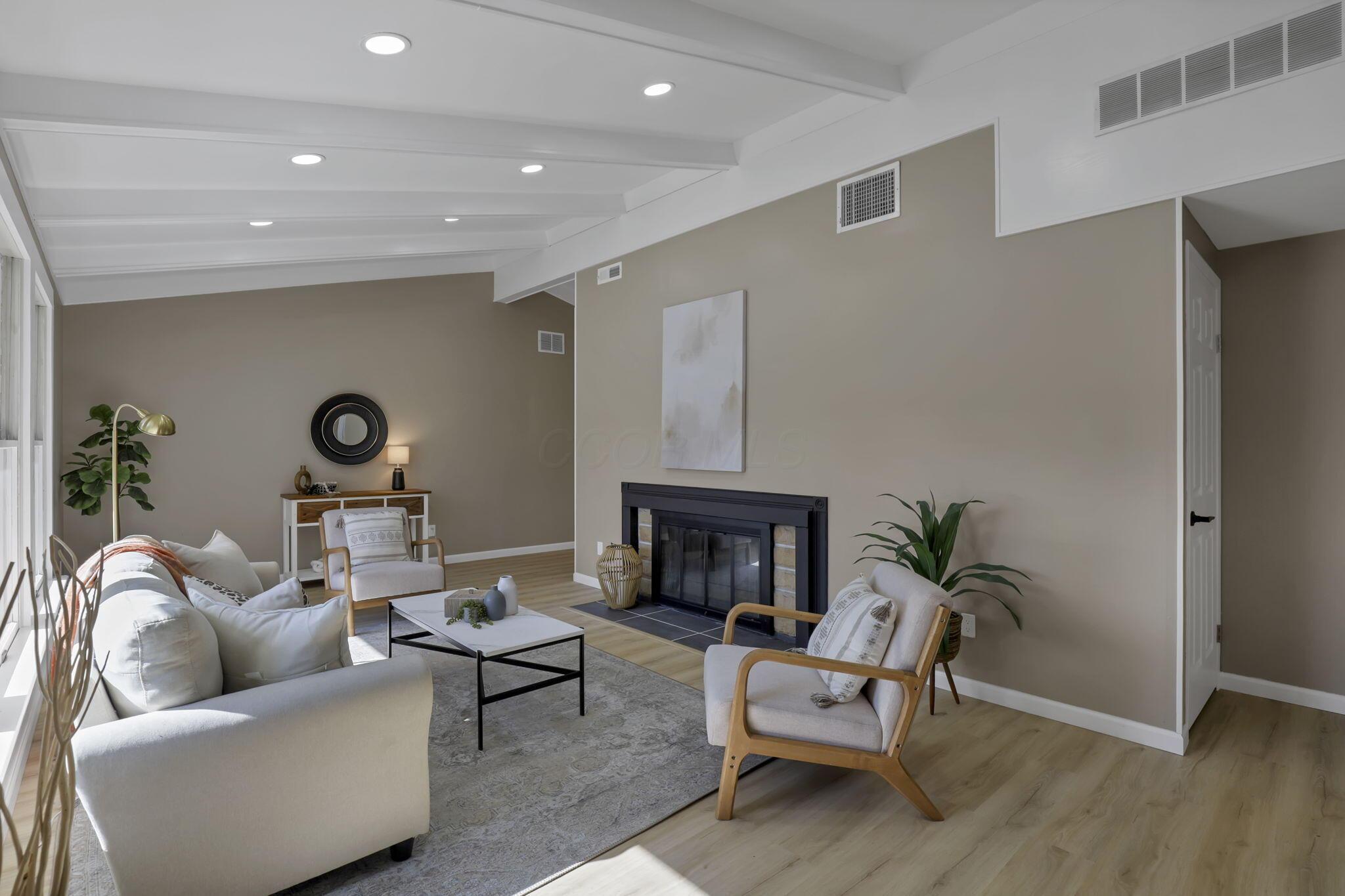 Enter into the sunlit living room with fireplace.