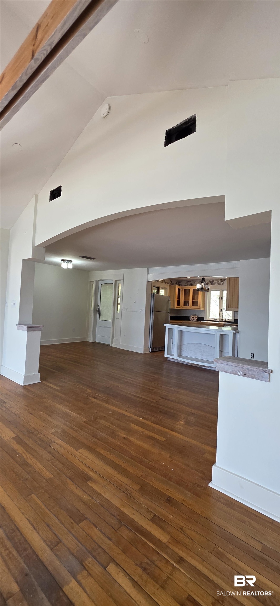 544 Windmill Ridge Road Gulf Shores, AL 36542 - Photo 14 of 50 Unfurnished living room with high vaulted ceiling, dark wood-style flooring, and a chandelier