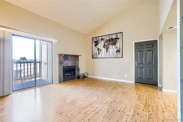 a view of an empty room with a fireplace and a window