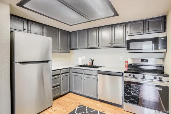 a kitchen with stainless steel appliances granite countertop a refrigerator sink and stove