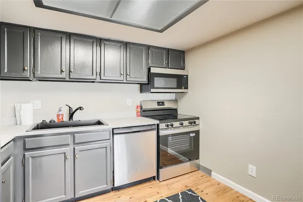 a kitchen with stainless steel appliances granite countertop a stove a sink and a microwave