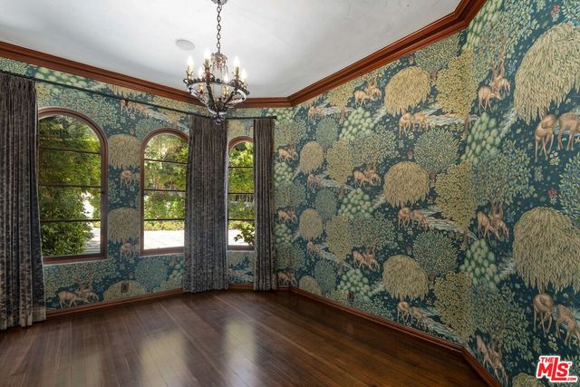 a view of a hallway with wooden floor and a living room