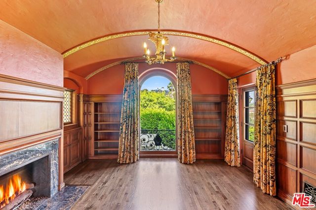 a view of a room with wooden floor and large windows