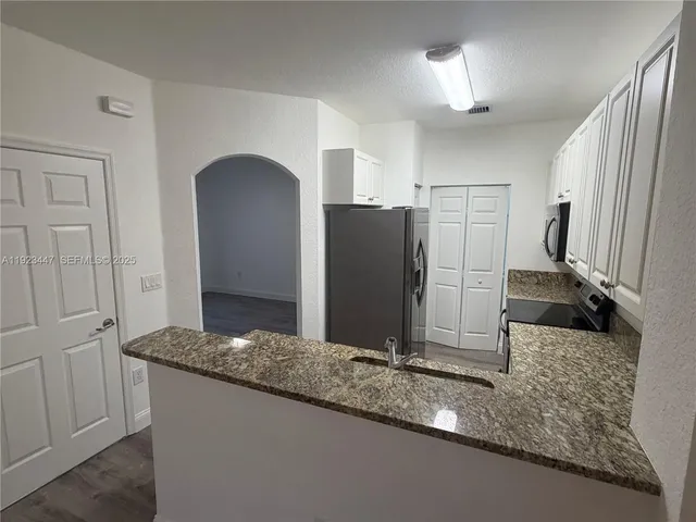 a bathroom with a granite countertop double vanity and a sink