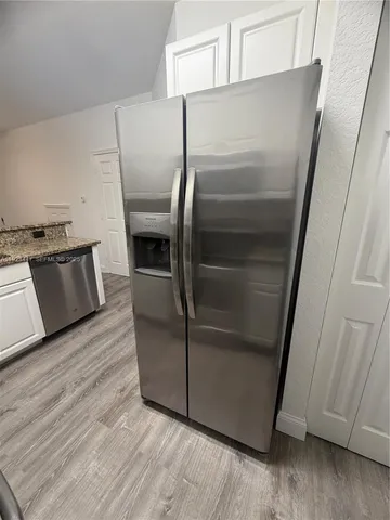 a metallic refrigerator freezer sitting in a kitchen