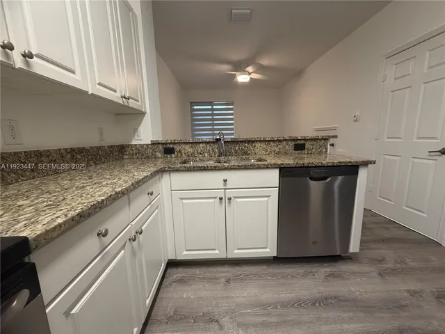 a kitchen with granite countertop a sink and cabinets
