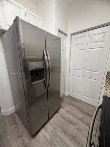 a metallic refrigerator freezer sitting in a kitchen