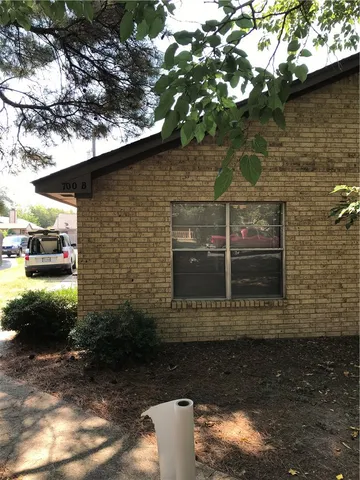 a view of a brick house with a large tree