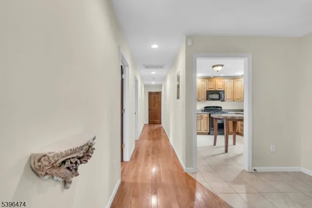 a view of a hallway with wooden floor and a living room