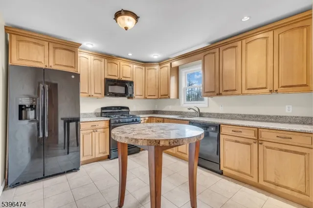 a kitchen with stainless steel appliances granite countertop a stove top oven a refrigerator a sink and dishwasher