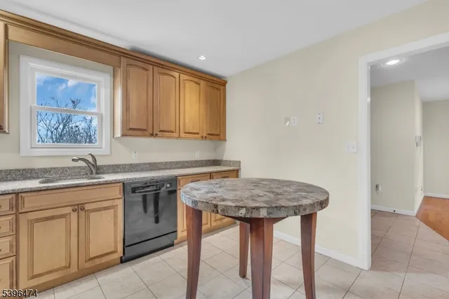 a kitchen with stainless steel appliances granite countertop a sink and a refrigerator