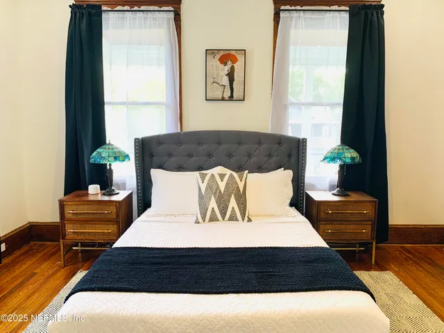 a large bed sitting in a bedroom next to a window