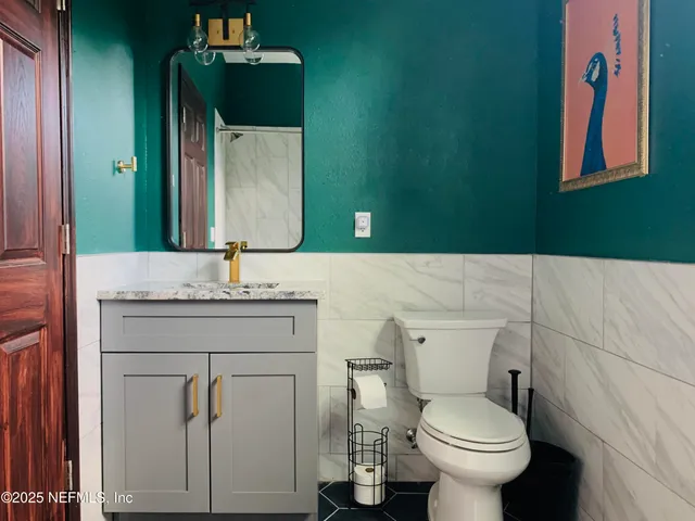 a bathroom with a toilet sink and mirror