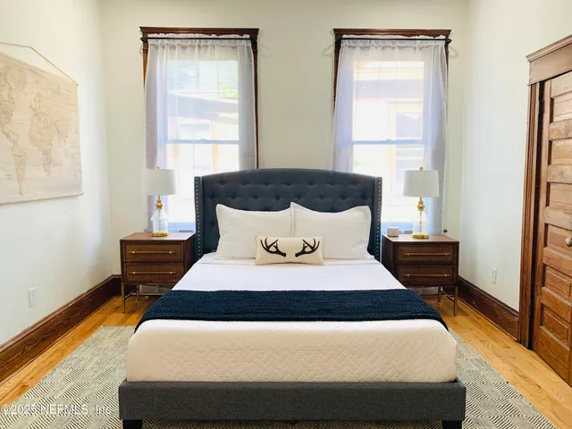 a bedroom with a bed and wooden floor