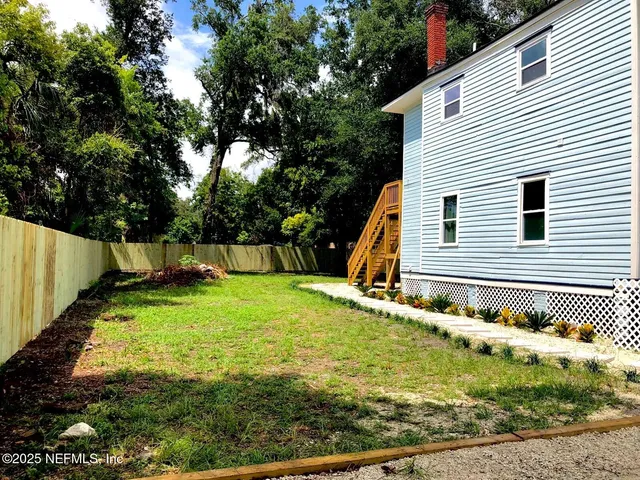a backyard of a house with a yard and outdoor seating