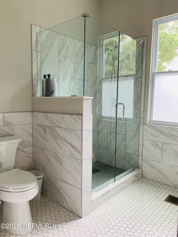 a bathroom with a toilet and a shower