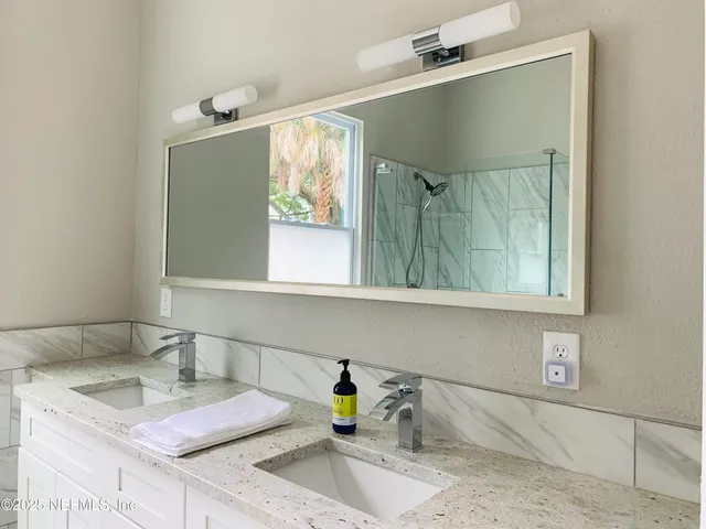 a bathroom with a granite countertop sink and a mirror