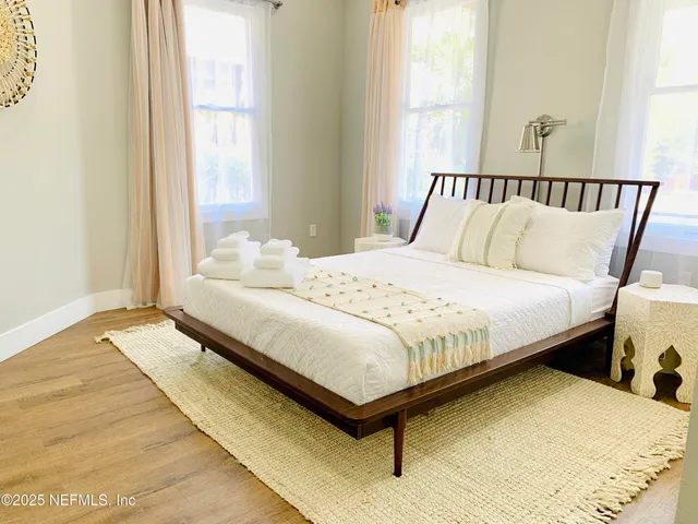 a large bed sitting in a bedroom next to a window