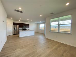 213 Saide Street Georgetown, TX 78626 - Photo 6 of 32 Open-concept living space featuring wood-finish flooring, recessed lighting, and ample natural light through multiple windows