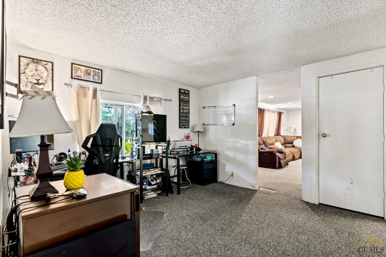 Undisclosed Address Bakersfield, CA 93306 - Photo 20 of 28 a room with furniture a lamp and a view of kitchen