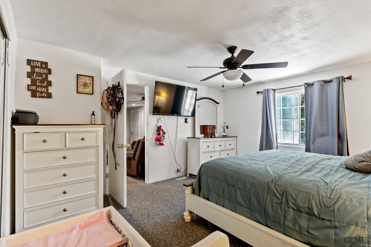 Undisclosed Address Bakersfield, CA 93306 - Photo 27 of 28 a bedroom with a bed a flat screen tv and a chandelier