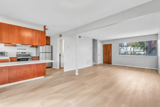 a view of a kitchen with a sink a refrigerator and window