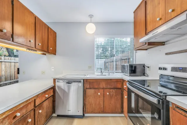 a kitchen with stainless steel appliances granite countertop a sink stove and cabinets