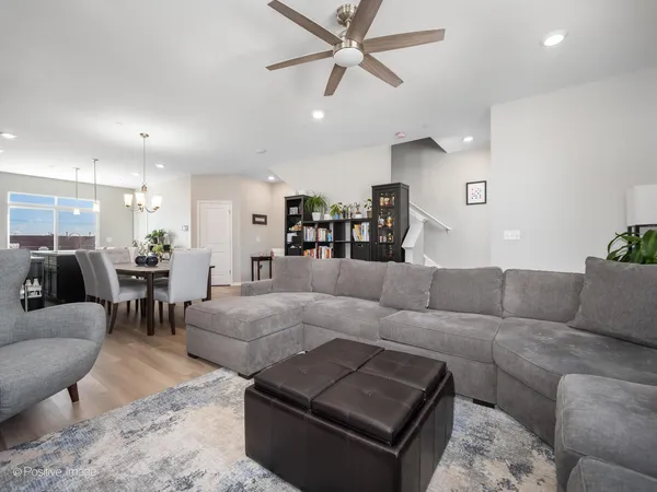 a living room with furniture and a view of kitchen