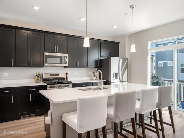 a kitchen with kitchen island a sink stove and refrigerator