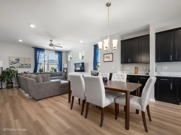 a living room with furniture a flat screen tv and kitchen view
