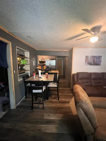 a living room with furniture a dining table and a refrigerator