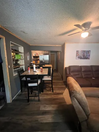 a living room with furniture and a dining table with wooden floor