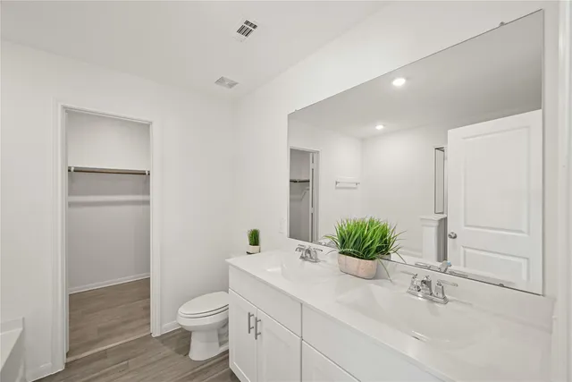 a bathroom with a granite countertop sink a toilet and a mirror