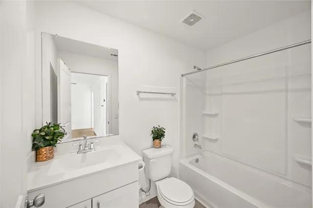 a bathroom with a sink a toilet a tub and shower