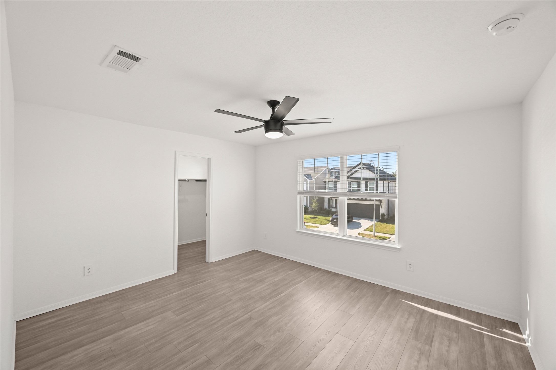 23442 Wrexham Street Spring, TX 77373 - Photo 25 of 33 an empty room with wooden floor ceiling fan and windows
