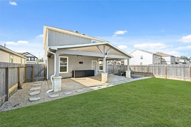 a patio with table and chairs and potted plants