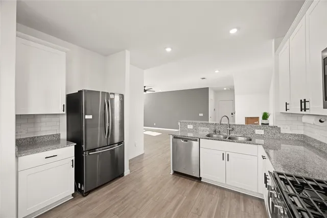 a kitchen with a refrigerator a sink and wooden cabinets