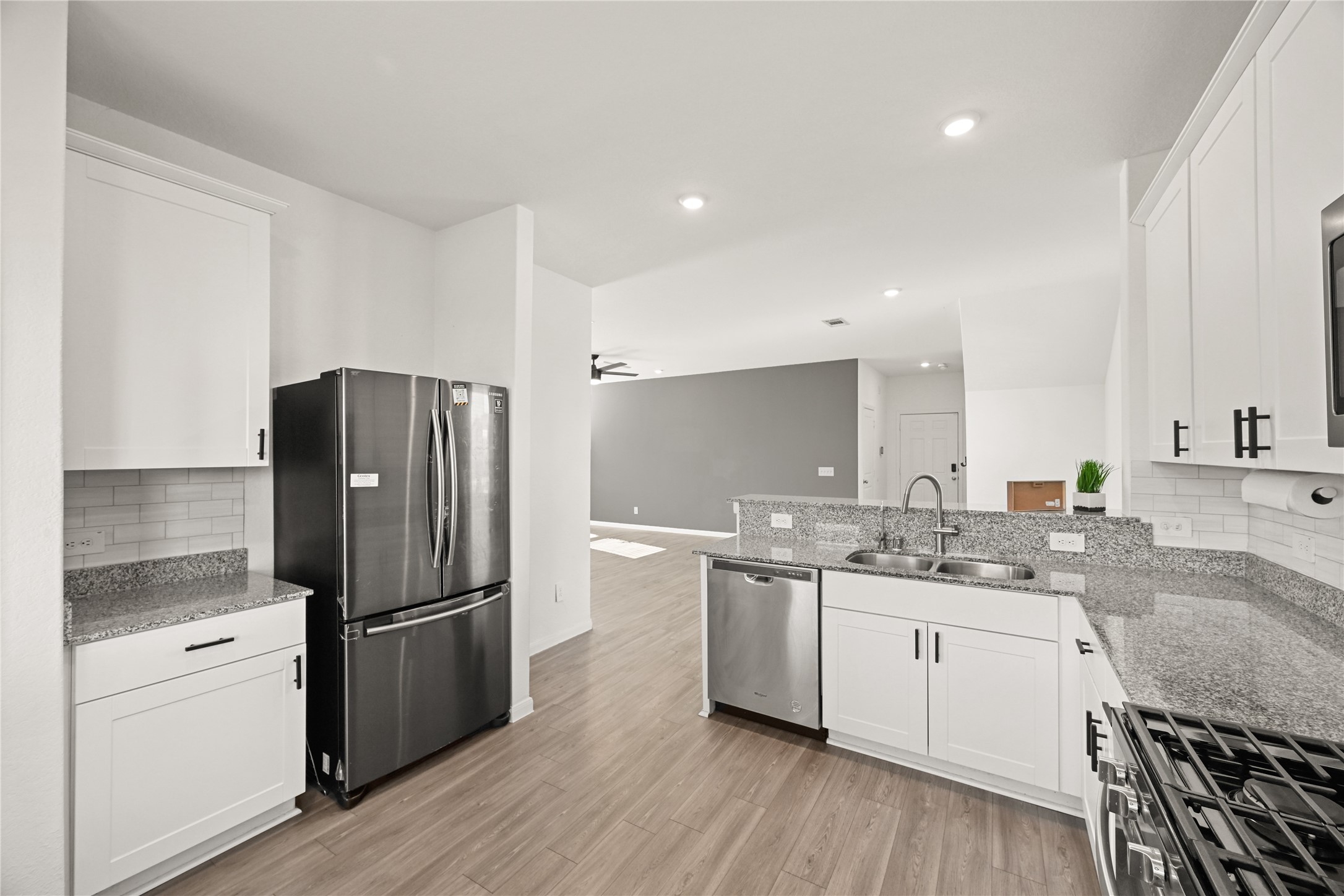 23442 Wrexham Street Spring, TX 77373 - Photo 3 of 33 a kitchen with a refrigerator a sink and wooden cabinets