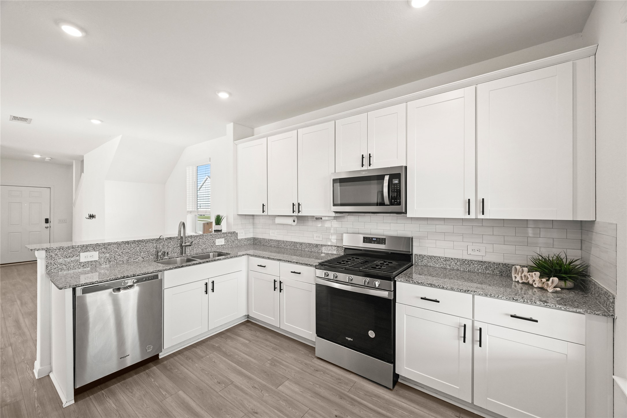 23442 Wrexham Street Spring, TX 77373 - Photo 4 of 33 a kitchen with stainless steel appliances granite countertop a stove a sink and white cabinets