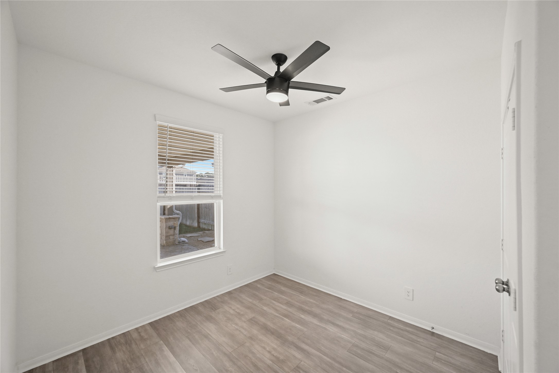 23442 Wrexham Street Spring, TX 77373 - Photo 8 of 33 an empty room with wooden floor a ceiling fan and windows