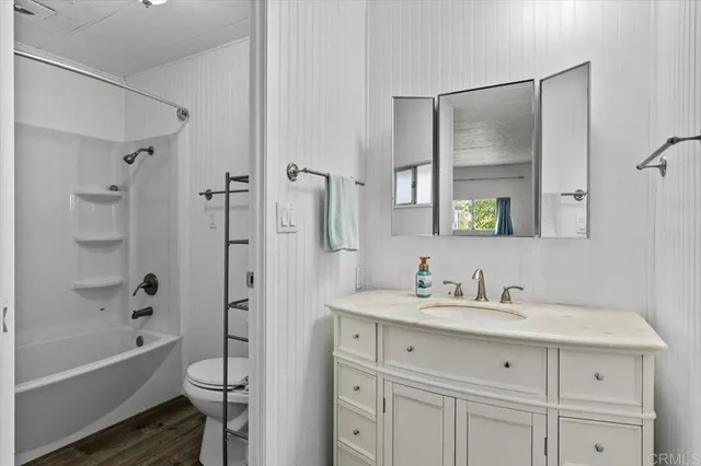 a bathroom with a tub sink toilet and a mirror